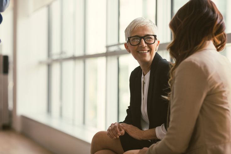 two women talking to each other in an office