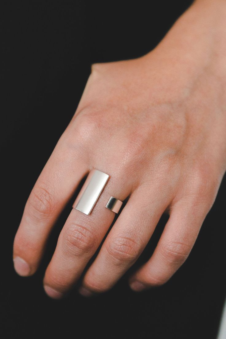 Arcus is an elegant asymmetrical ring made of solid 925 sterling silver, featuring a sparkling matte finish. The ring has an eye-catching statement look, yet It's very light and comfortable for everyday wear.  Customers from the USA: you don't need to worry about converting the standard US measurements into millimeters. Simply click on any size and write the size you are used to in the "note to the seller" section at the checkout. Front rectangle measurements: Length: 21 mm / 0.8 " Width: 14 mm Minimalist Silver Rings, Silver Handmade Ring, Thick Silver Rings, Thick Silver Ring, Modern Silver Ring, Asymmetrical Ring, Silver Cuff Ring, Modern Silver Jewelry, Wide Silver Ring