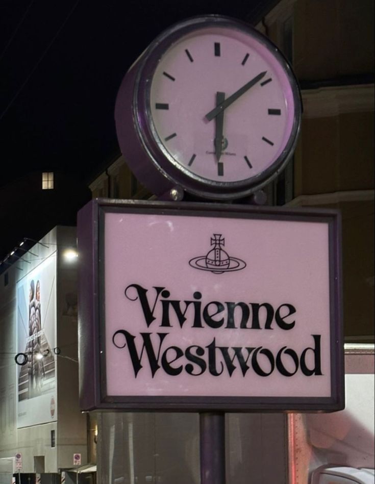 a sign that says viviene westwood with a clock on top of it