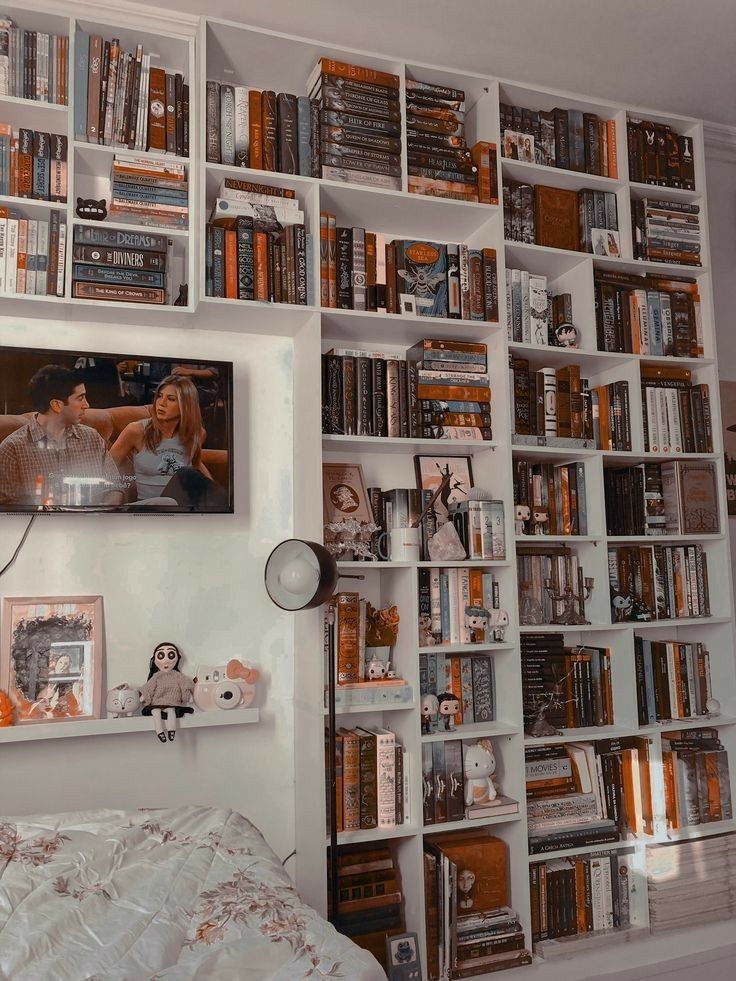 a bedroom with bookshelves and pictures on the wall