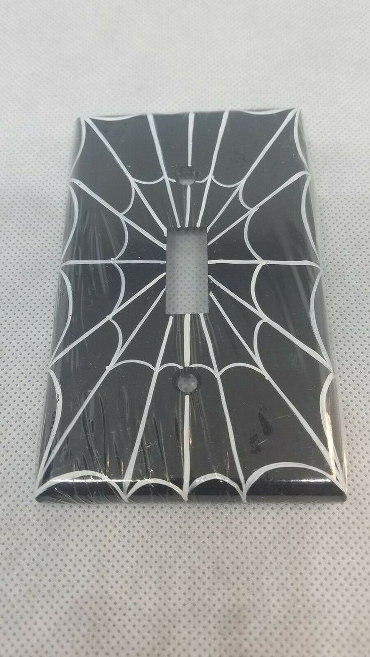 a black and white spider web tile on the floor with a square hole in it