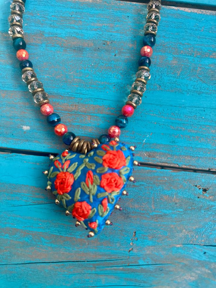 Hand stitched and beaded, this pretty turquoise heart is complimented with a strand of coordinating beads and crystals. the leather straps makes this necklace an adjustable piece. Valentine's Day Bohemian Beaded Jewelry, Bohemian Beaded Jewelry For Valentine's Day, Adjustable Heart Necklace With Heart Beads And Pendant, Blue Adjustable Heart-shaped Beaded Necklaces, Adjustable Heart Pendant Necklace With Heart Beads, Adjustable Blue Heart Beaded Necklaces, Adjustable Blue Heart-shaped Beaded Necklaces, Adjustable Blue Heart-shaped Beaded Necklace, Bohemian Heart Shaped Necklace