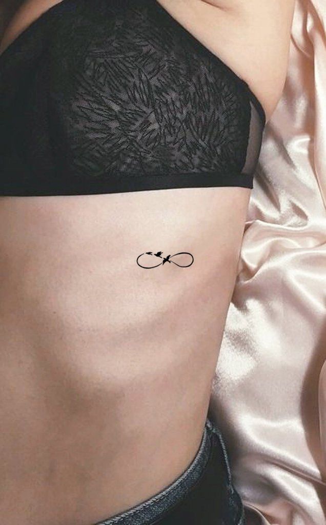 a woman's stomach with an intricate tattoo on her side, and the word love is