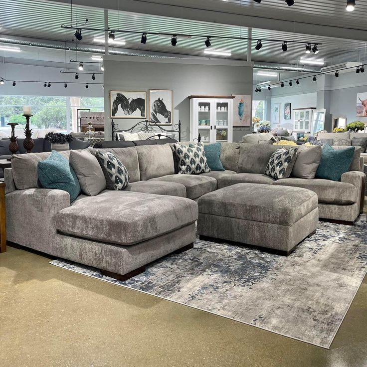 a living room filled with lots of furniture and pillows on top of a carpeted floor