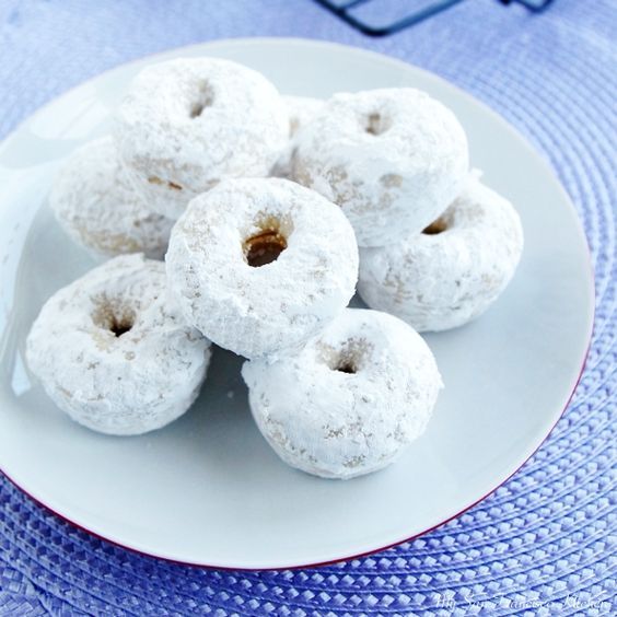 powdered donuts are on a white plate