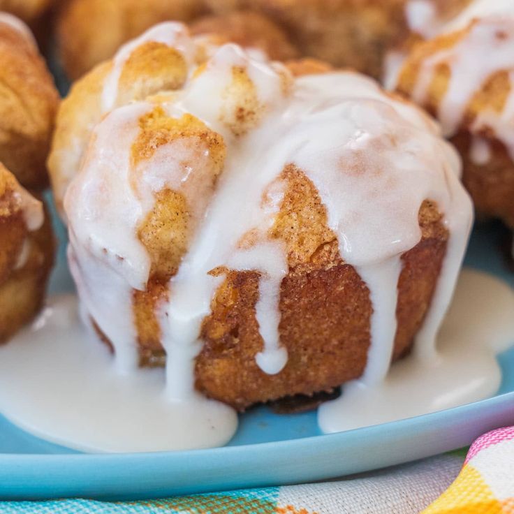 a plate topped with donuts covered in icing on top of a blue plate