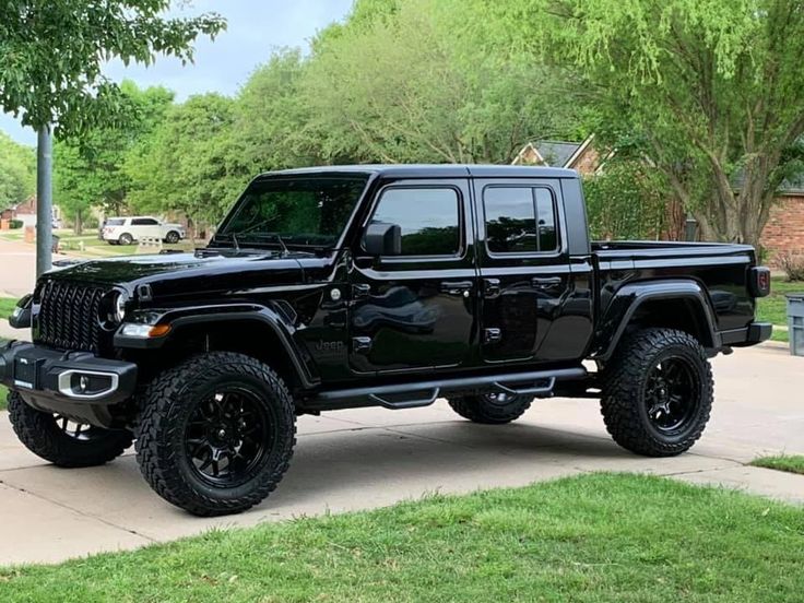 a black jeep is parked on the sidewalk