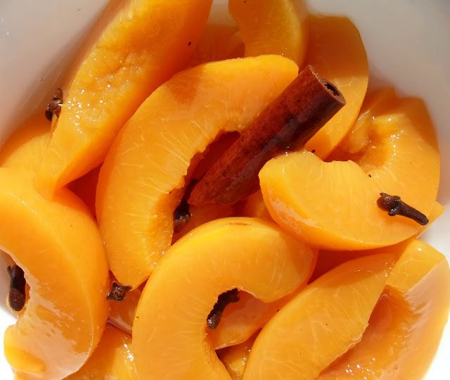 a white bowl filled with sliced peaches on top of a table