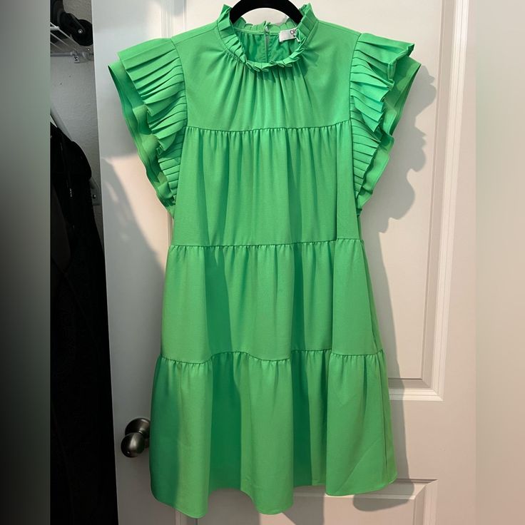 a green dress hanging on a white door