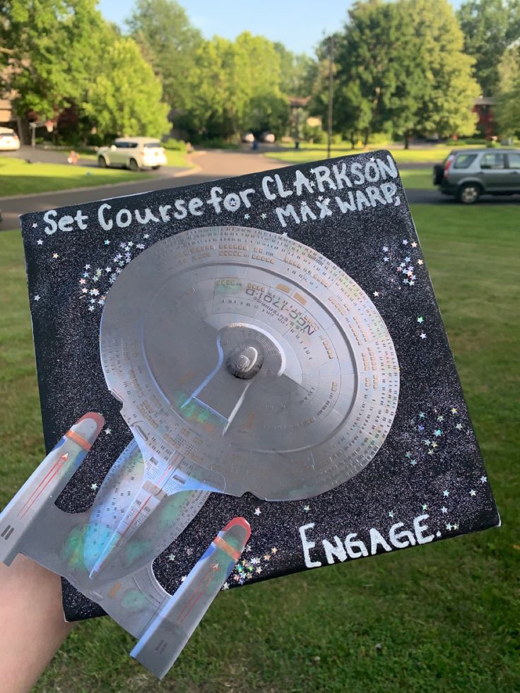 a person holding up a book with an image of a space shuttle on it's cover