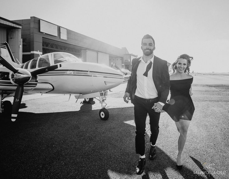 a man and woman walking towards an airplane