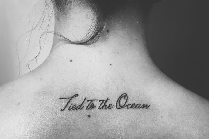 the back of a woman's neck with a tattoo that reads, ted is the ocean