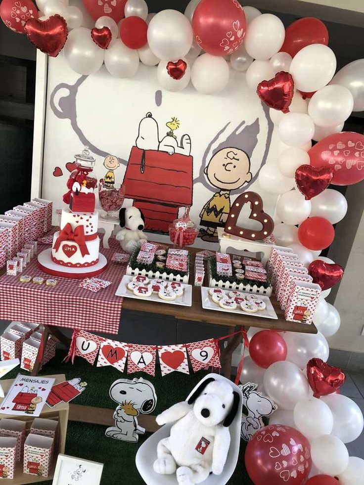 a table topped with lots of red and white balloons