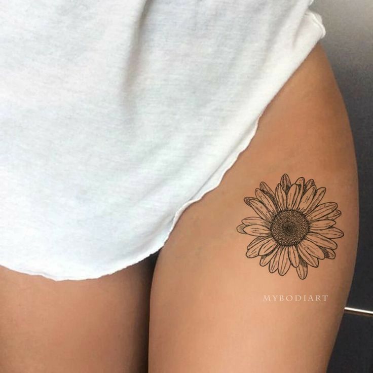 a woman's thigh with a sunflower tattoo on it