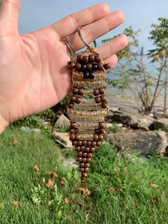 a hand holding a brown beaded key chain