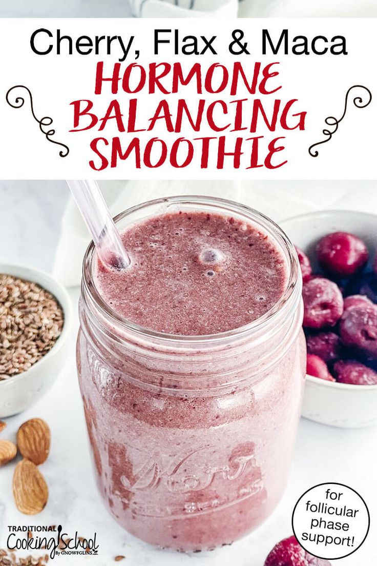 a close up of a jar of smoothie with berries and nuts in the background