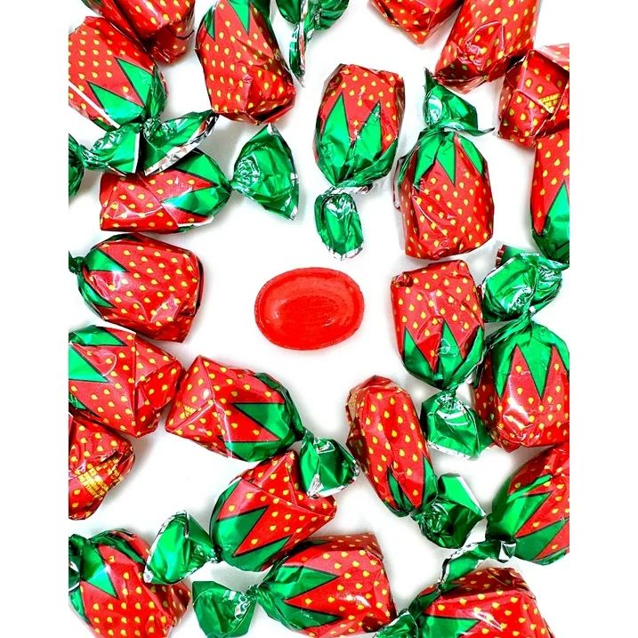 some candy wrapped in green and red foil with strawberries on them, sitting next to each other