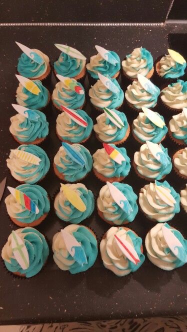 cupcakes with blue frosting and white icing on a black table top