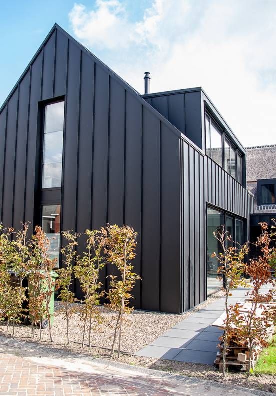 a black house with lots of windows on the front and side of it's building