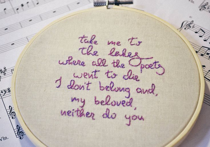 a close up of a embroidery on a piece of paper with musical notes in the background