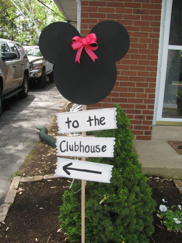 a minnie mouse sign with the words to the clubhouse on it in front of a house