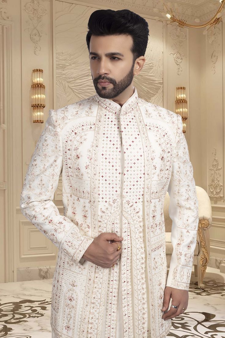 This Mens Sherwani features a layered design. Expertly crafted for grooms, Features stunning red accents to add a touch of traditional elegance to your special day. Exude confidence and style as you walk down the aisle in this expertly designed sherwani. Traditional Festive Suits For Reception, Fitted Nehru Jacket For Groom In Transitional Season, Bollywood Wedding Suits With Dabka, Traditional Fit Long Sleeve Sherwani For Wedding, Long Nehru Jacket For Wedding And Transitional Seasons, Long Nehru Jacket For Weddings And Transitional Seasons, Traditional Fit Long Sleeve Wedding Sherwani, Wedding Red Bandhgala With Long Sleeves, Bollywood Style Suits With Traditional Drape For Weddings