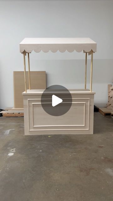 a white table with a canopy on top and some boxes in the back ground next to it