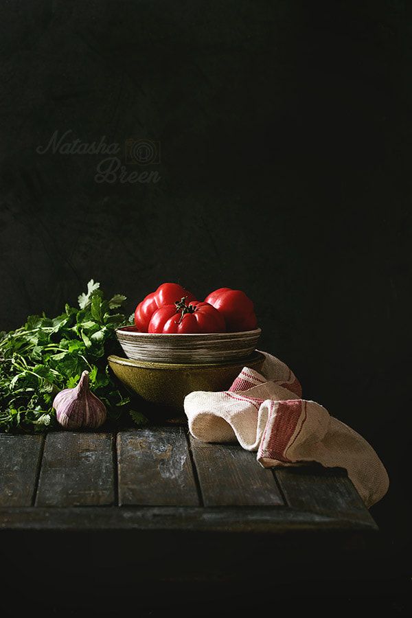 tomatoes, parsley and garlic in a bowl on a wooden table