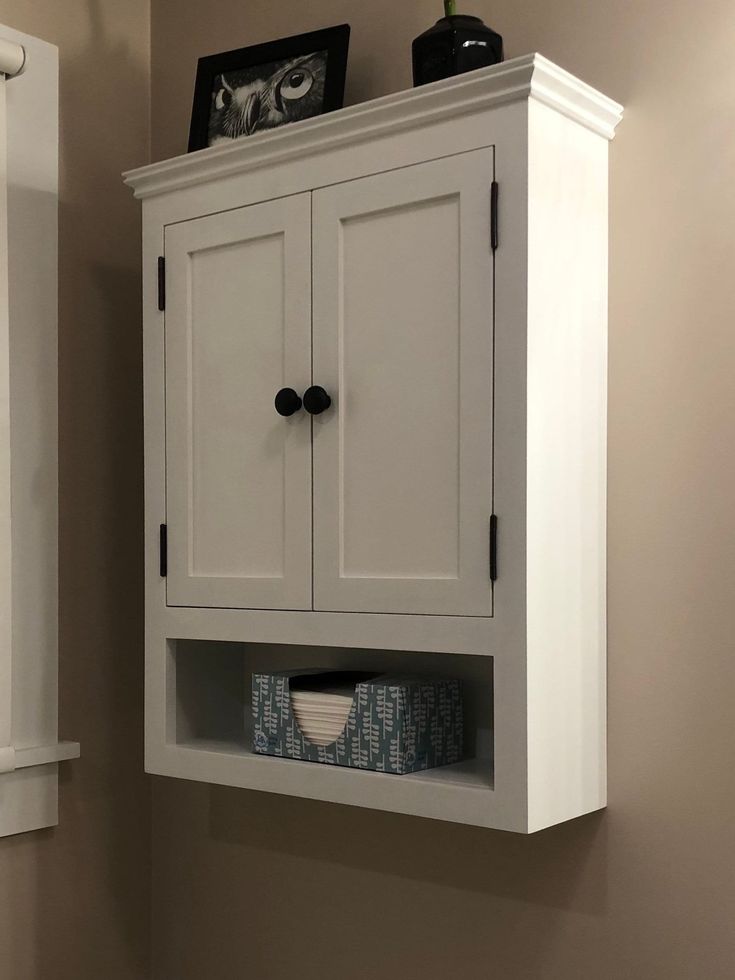 a white cabinet with two doors on the wall