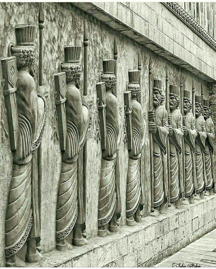 a line of statues on the side of a building