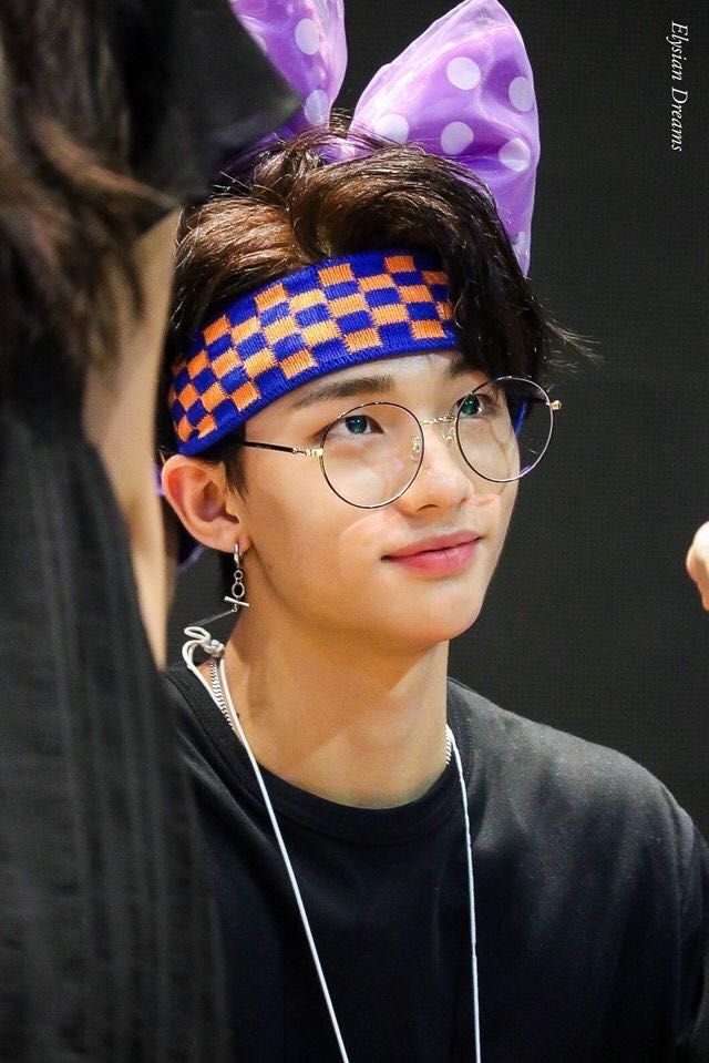 a young boy with glasses and a purple bow on his head