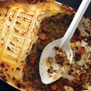 a casserole dish with meat, vegetables and cheese in it on a table