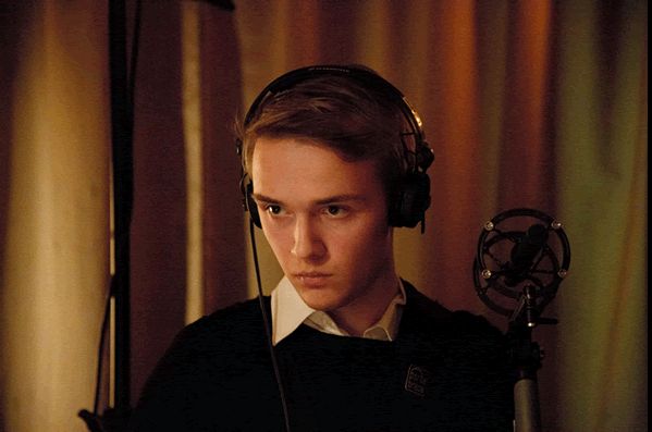 a young man wearing headphones in front of a microphone