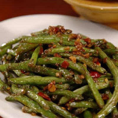 a white plate topped with green beans covered in seasoning