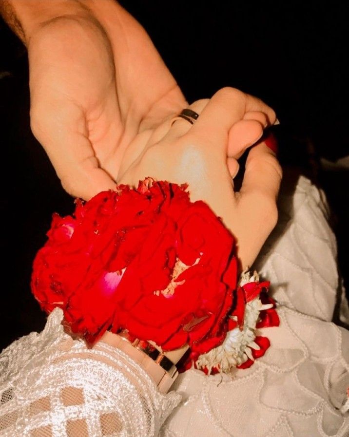 the woman is wearing a red flower on her wrist