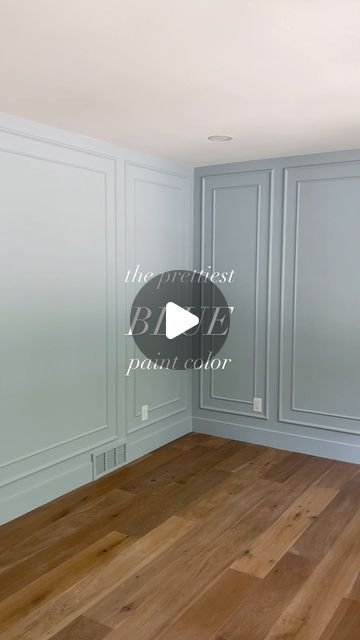 an empty room with blue walls and wood floors