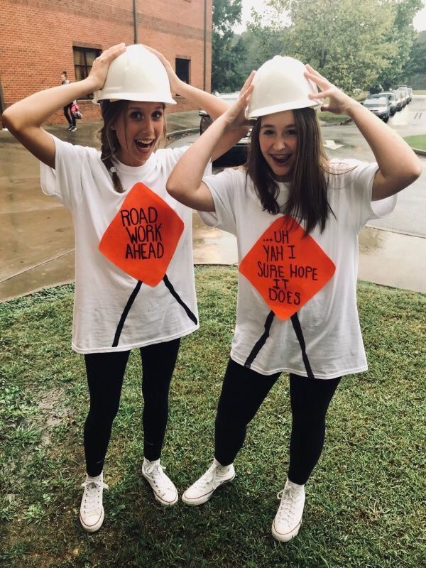 two girls wearing hard hats and t - shirts with road work ahead signs on them