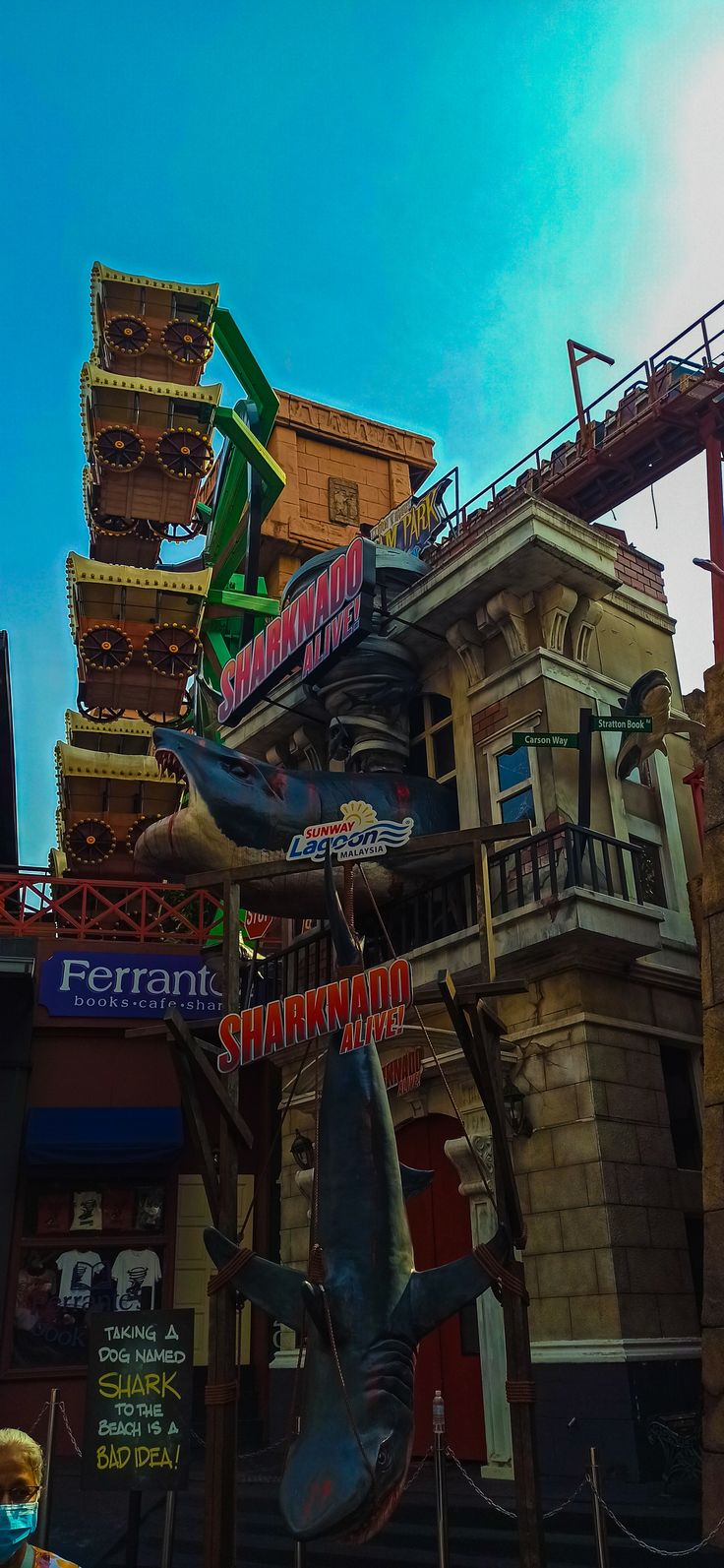 a statue of a shark is in front of a building with many signs on it