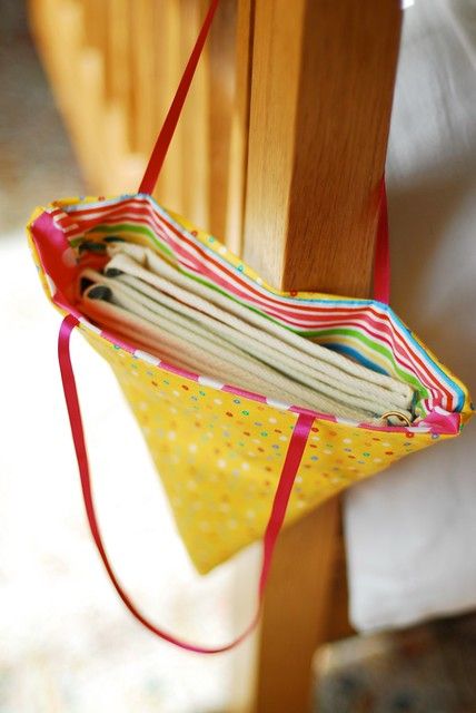 a close up of a cloth bag hanging from a wooden cross - country style beam