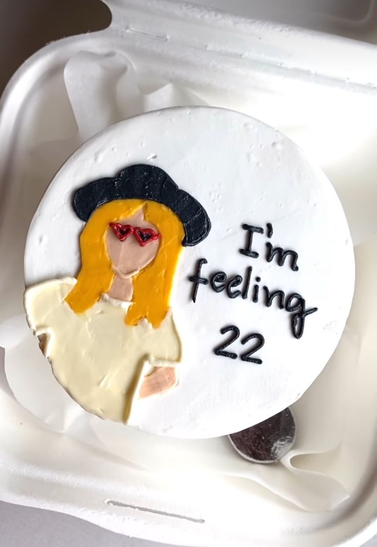 a cake decorated with the words i'm feeling 22 and a woman in a hat