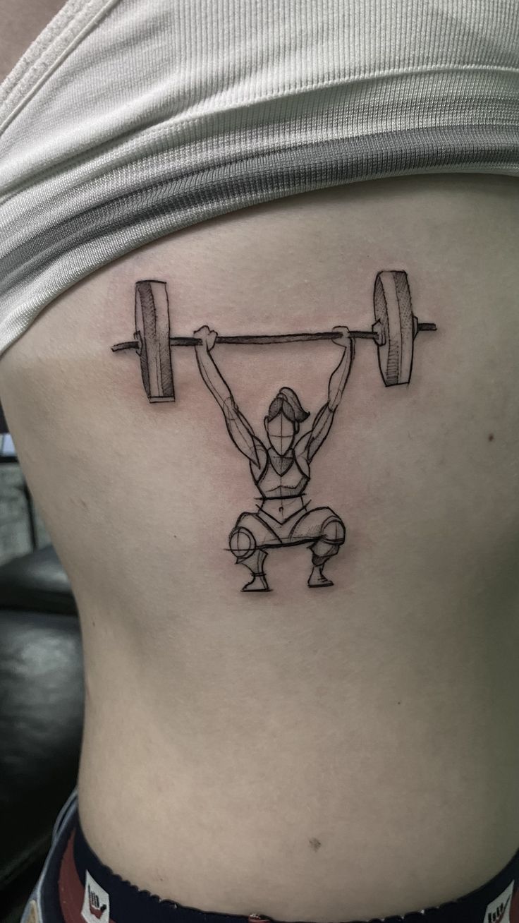 a woman with a barbell tattoo on her stomach