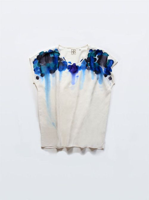 a white t - shirt with blue flowers painted on it