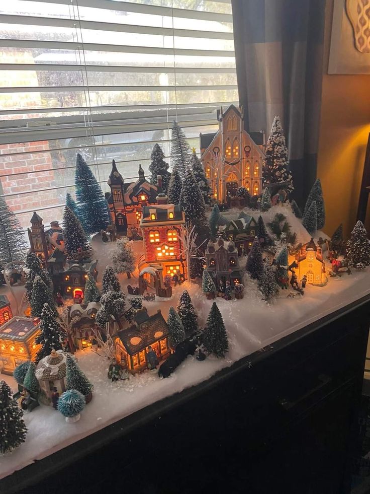 a christmas village is shown in front of a window