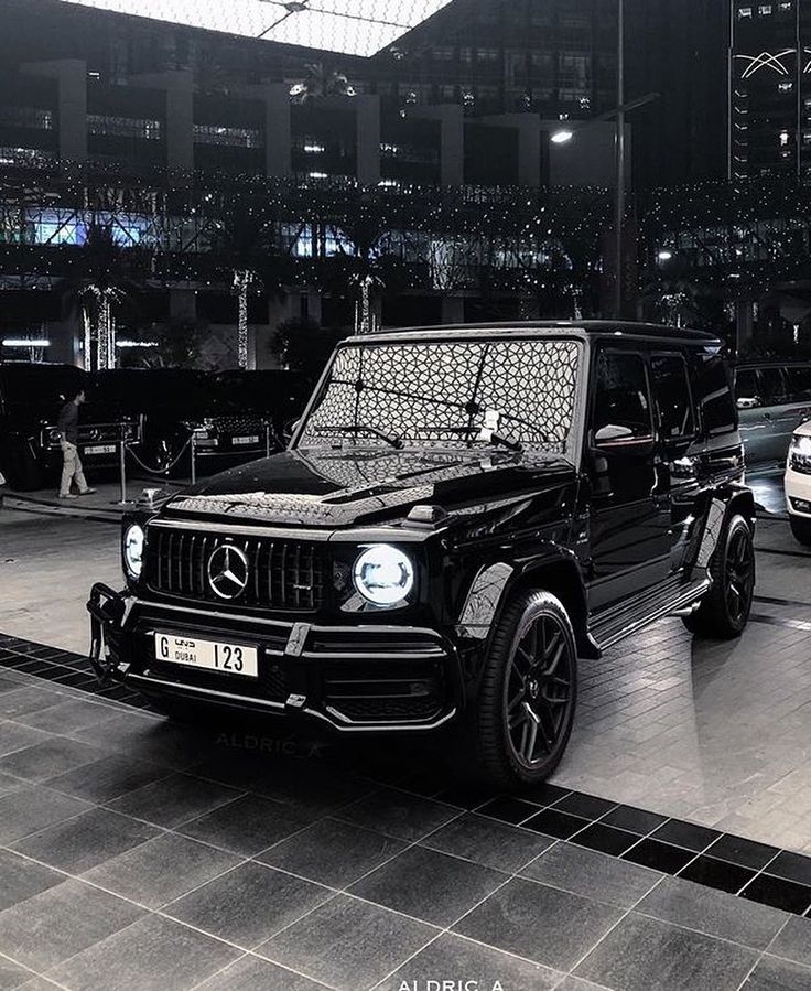 the mercedes g - class is parked in front of other cars at an auto show