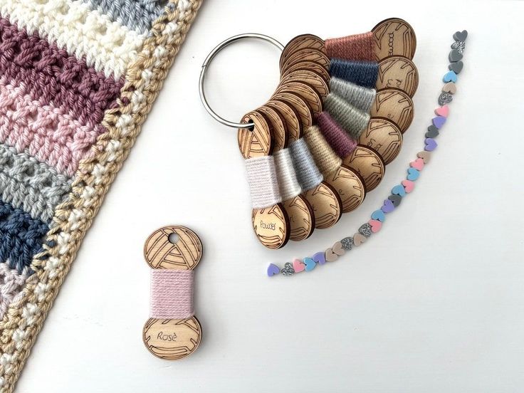 a crocheted rug, keychain and wooden beads on a white surface