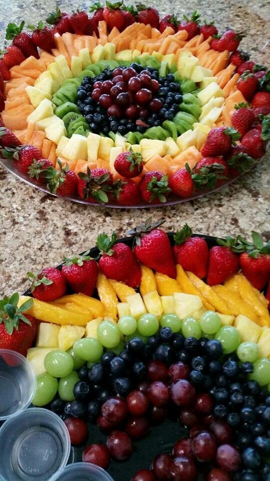 two trays filled with different types of fruit on top of a table next to each other