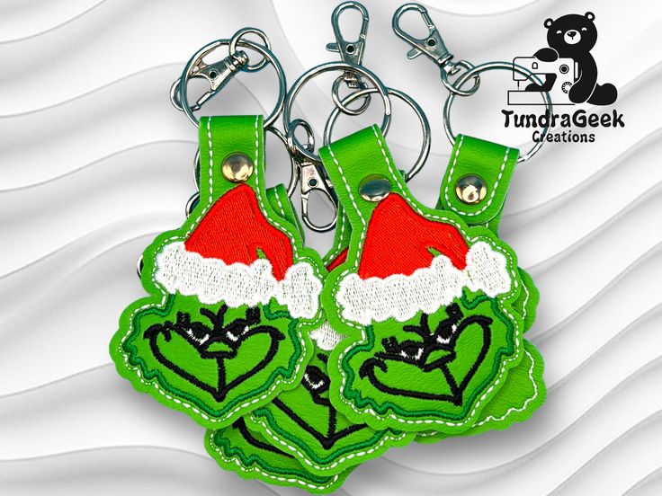 two green key chains with santa hats on them