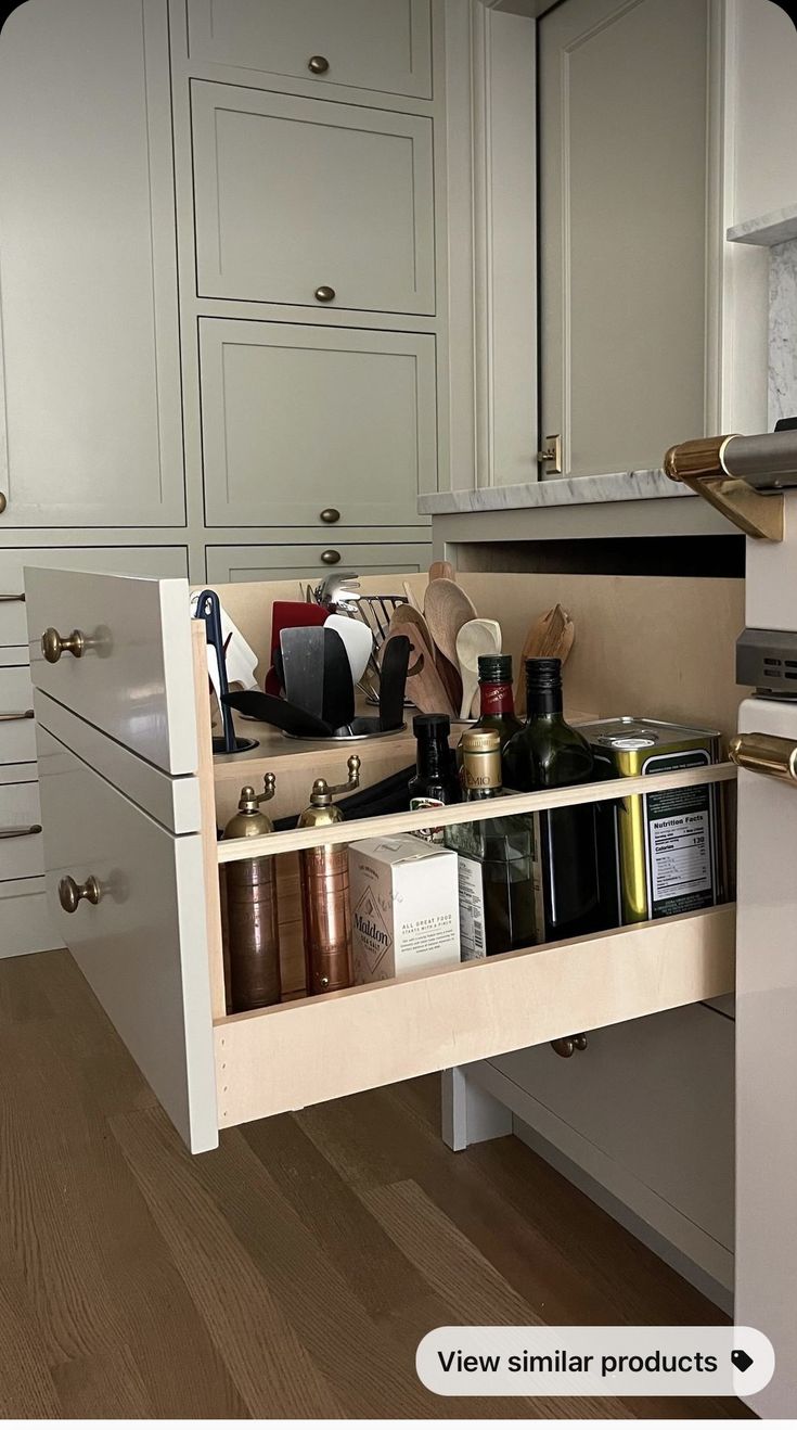 an open drawer in the middle of a kitchen with lots of spices and condiments