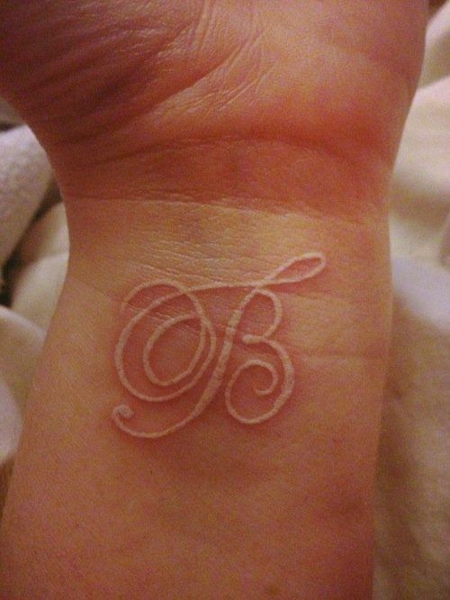 a small tattoo on someone's wrist with the number eighty written in cursive writing