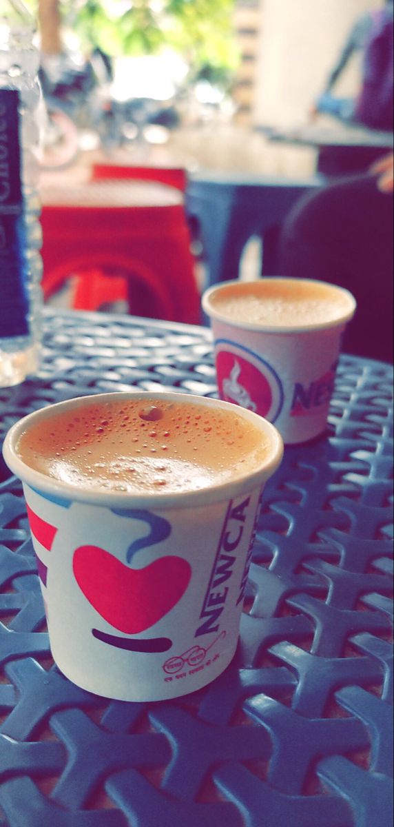 two cups of coffee sitting on top of a table